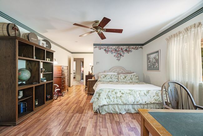 Bedroom with ornamental molding, wood finished floors, and ceiling fan | Image 15