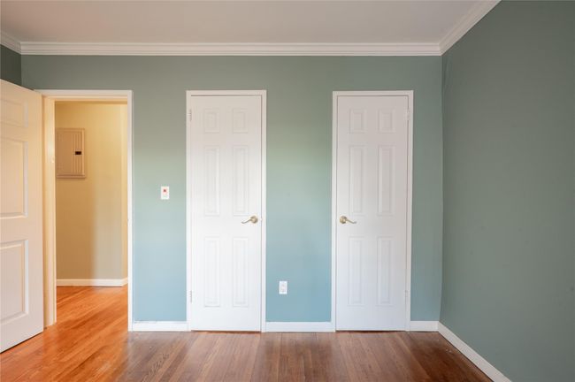 Empty room with baseboards, ornamental molding, radiator, wood-type flooring, and a wall unit AC | Image 5
