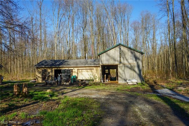 View of outdoor structure featuring driveway and a wooded view | Image 5