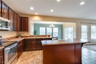 Kitchen featuring stainless steel appliances, sink, a breakfast bar area, and a center island | Image 3