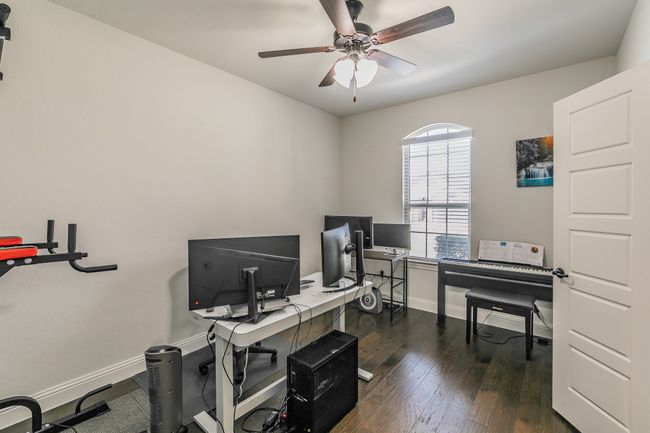 Home office with dark wood-style floors, a ceiling fan, and baseboards | Image 8