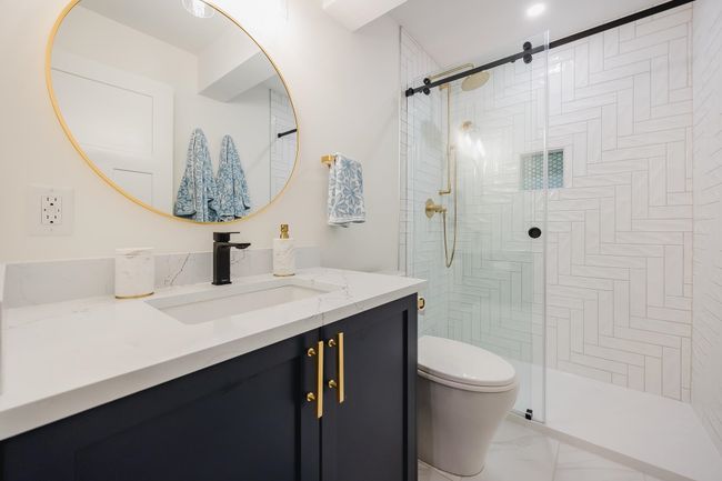 Bathroom featuring tiled shower, vanity, and toilet | Image 30
