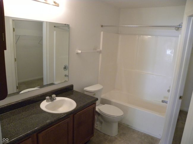 primary ensuite bathroom with a spacious closet, vanity, shower / bathtub combination | Image 13