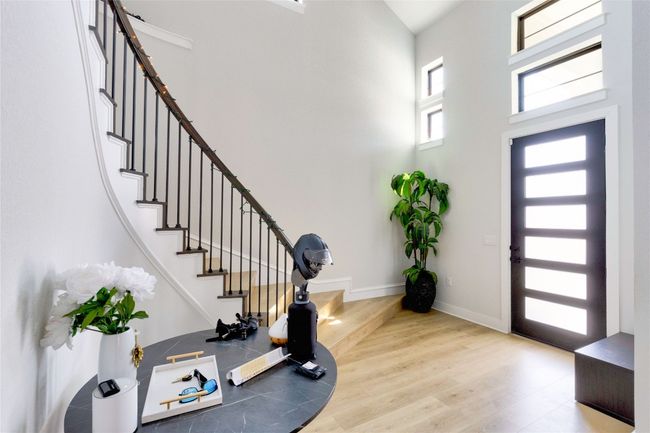 Foyer entrance featuring baseboards, a high ceiling, wood finished floors, and stairs | Image 8
