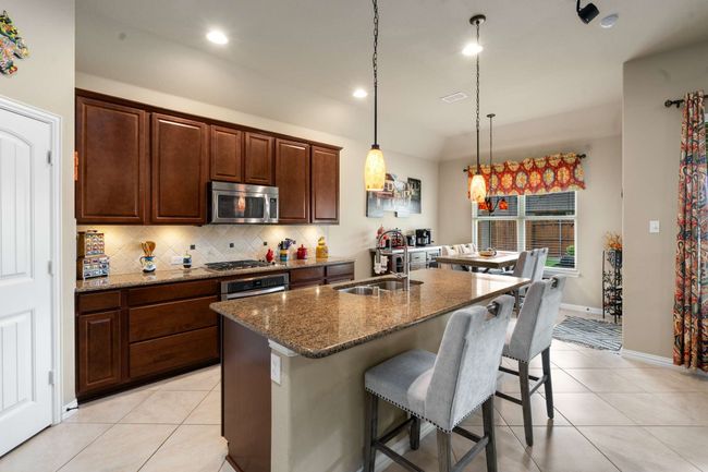 Kitchen featuring a sink, stainless steel appliances, light tile patterned floors, backsplash, and recessed lighting | Image 13