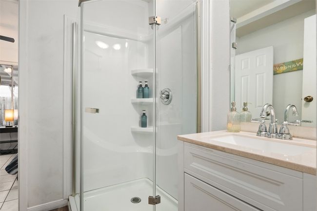 Full bath with a shower stall, vanity, and tile patterned flooring | Image 12