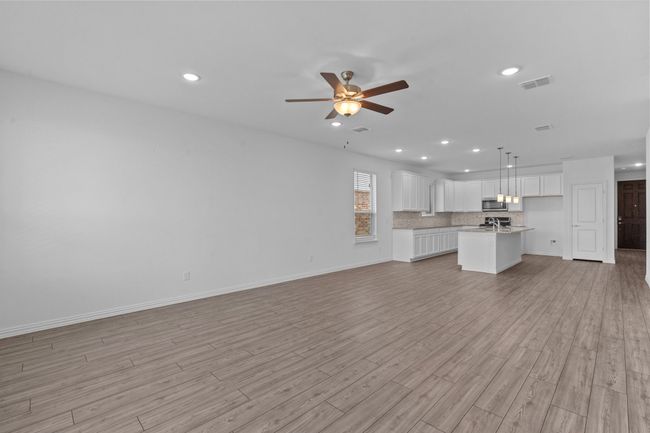 Unfurnished living room with a ceiling fan, light wood-style floors, and recessed lighting | Image 9