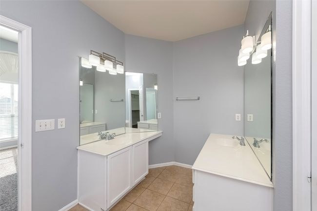 Full bath with baseboards, two vanities, a sink, and tile patterned floors | Image 32