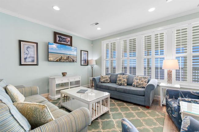 Oceanfront Living area with LVT floors, coastal decor, and plenty of natural light | Image 19