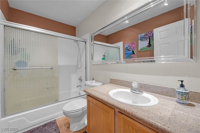 Full bathroom with bath / shower combo with glass door, toilet, and vanity | Image 21