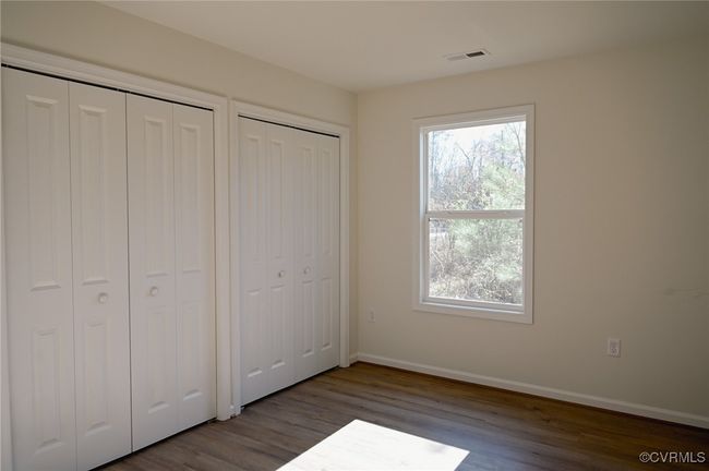 Unfurnished bedroom with dark hardwood / wood-style floors and multiple closets | Image 8
