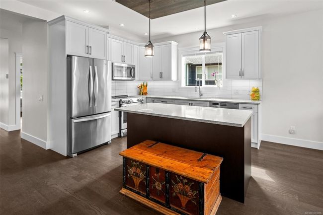 Kitchen featuring stainless steel appliances, dark wood-type flooring, backsplash, recessed lighting, and a kitchen island | Image 15