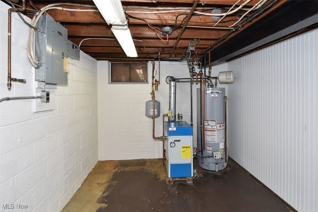 Utility room featuring water heater, a heating unit, and electric panel | Image 43