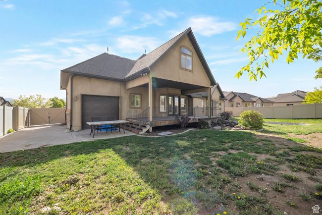 Back of property with a patio, a gate, a garage, stucco siding, and a fenced backyard | Image 47