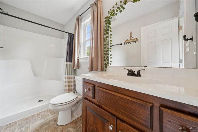 Bathroom with toilet, vanity, and a shower with shower curtain | Image 9