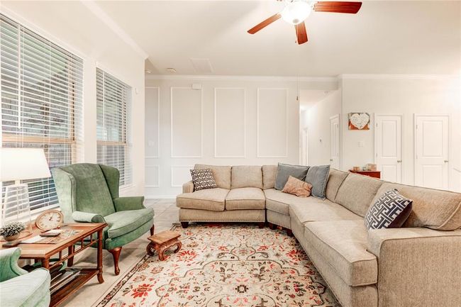Open living room with custom woodwork on main wall and crown molding | Image 17