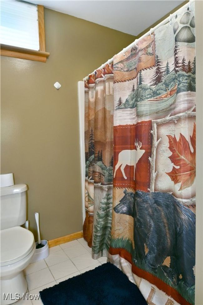 Bathroom featuring tile patterned flooring, toilet, a shower with curtain, and baseboards | Image 43