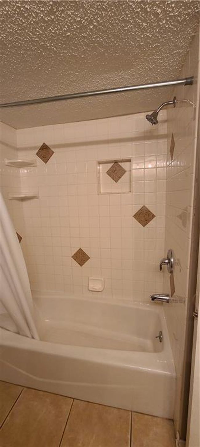 Bathroom with tile patterned flooring and shower / tub combo with curtain | Image 8