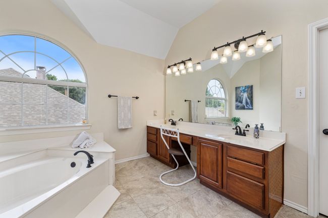 Bathroom featuring vaulted ceiling, double vanity, a garden tub, and tile patterned flooring | Image 26