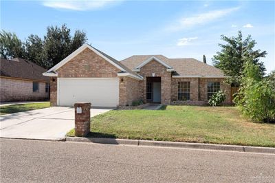 Ranch-style house with a garage and a front lawn | Image 1