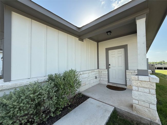 Property entrance featuring board and batten siding and stone siding | Image 4