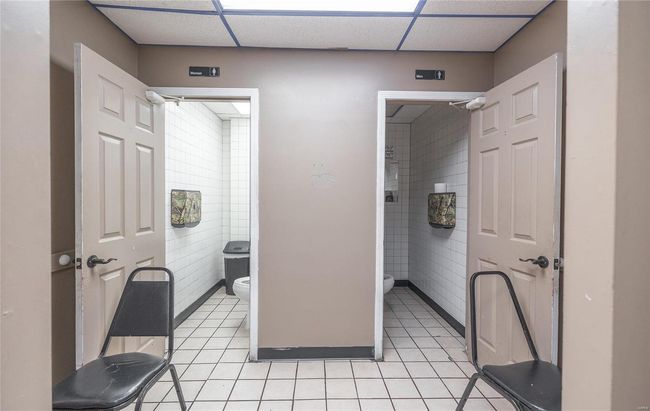 Bathroom with a drop ceiling, tile patterned floors, and toilet | Image 10