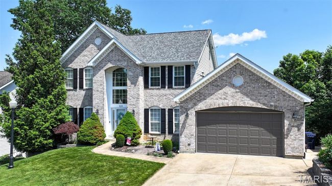 View of front of property with concrete driveway, an attached garage, a front yard, and brick siding | Image 57