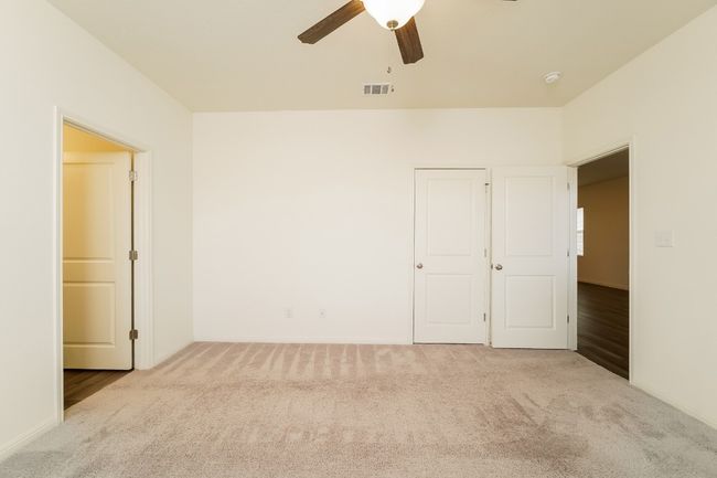 Carpeted empty room featuring a ceiling fan and baseboards | Image 13
