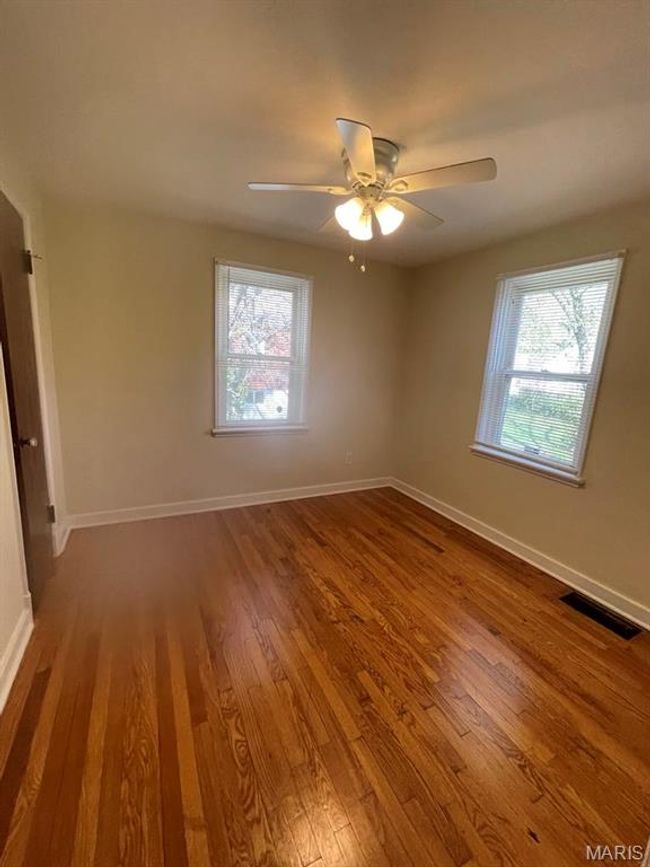 Spare room featuring wood finished floors, visible vents, baseboards, and ceiling fan | Image 16