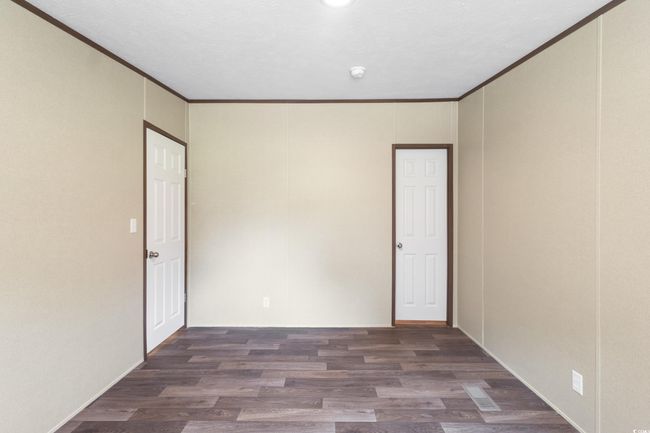 Empty room with crown molding, wood finished floors, and a smoke detector | Image 26
