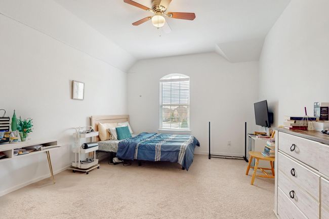 Bedroom with light carpet, ceiling fan, baseboards, and lofted ceiling | Image 37