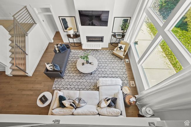 Living room featuring wood finished floors, stairway, and a glass covered fireplace | Image 10
