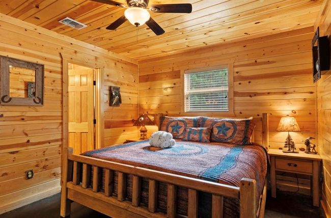 Bedroom with wood ceiling, wooden walls, and ceiling fan | Image 19