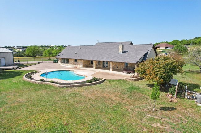 View of pool featuring a patio area, a fenced in pool, fence, a lawn, and grilling area | Image 33