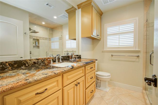 The secondary bathroom has gorgeous granite, ample storage, and an oversized walk-in shower. | Image 25
