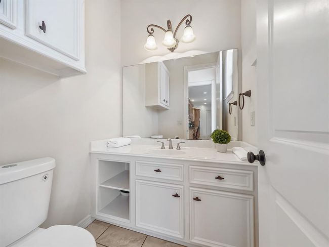 Convenient downstairs half bath with modern fixtures and ample storage. | Image 33