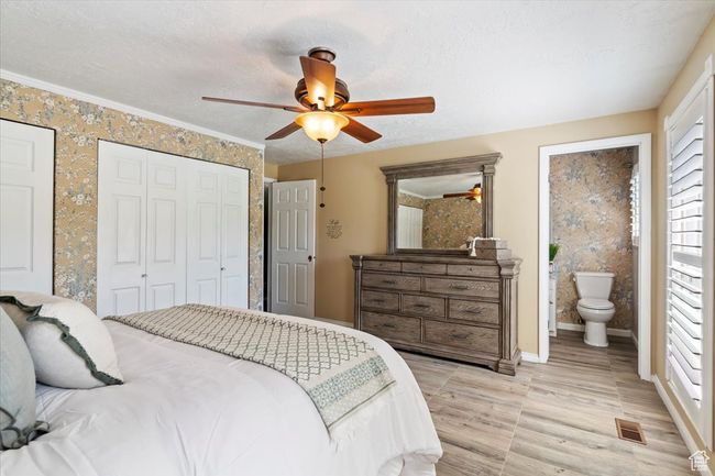 Bedroom featuring baseboards, ensuite bath, ceiling fan, and light wood-style floors | Image 18