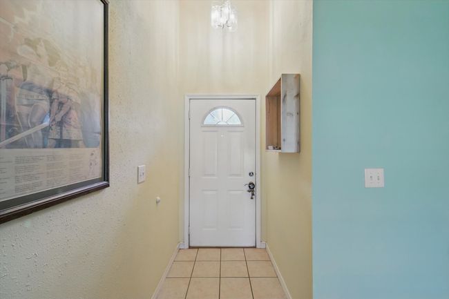 Doorway to outside featuring light tile patterned floors and baseboards | Image 4