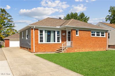 View of front facade with a front yard, a garage, and an outbuilding | Image 2