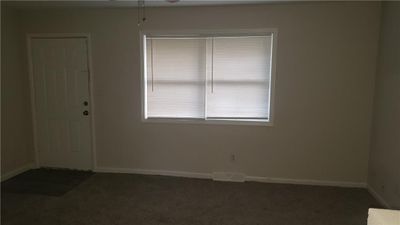 Carpeted spare room with a wealth of natural light and ceiling fan | Image 2