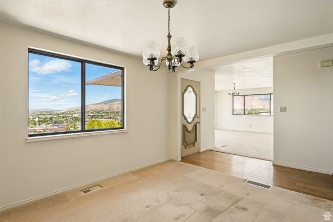 Spare room with a chandelier, carpet, wood finished floors, and a mountain view | Image 6