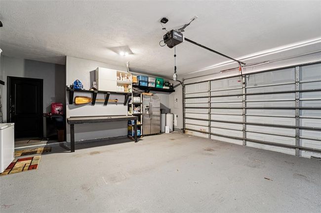 The home's attached 2-car garage features a collapsible workbench and built-in shelving. | Image 47