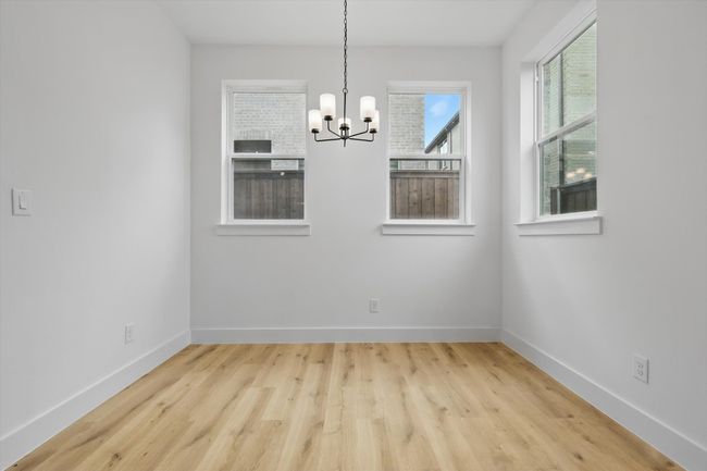 Unfurnished dining area with a chandelier, wood finished floors, and baseboards | Image 20