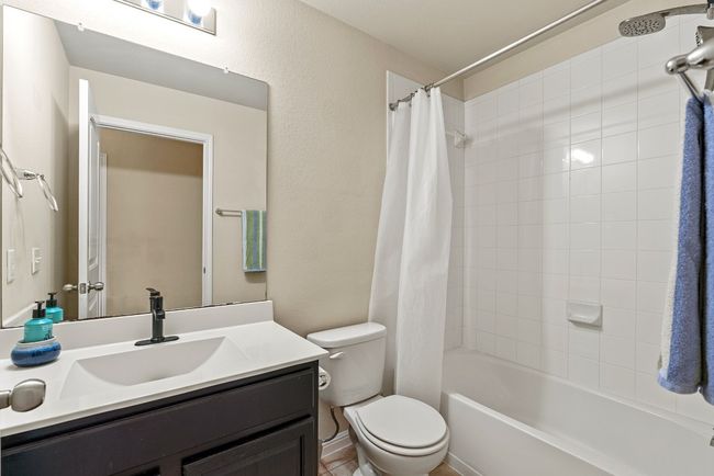 Bathroom with toilet, vanity, and shower / bath combination with curtain | Image 12