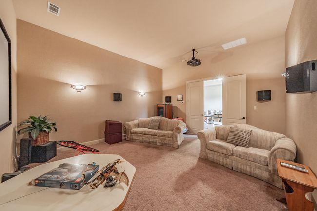Carpeted living room featuring vaulted ceiling and baseboards | Image 32