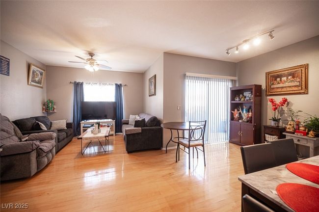 Living area with ceiling fan and light wood finished floors | Image 13