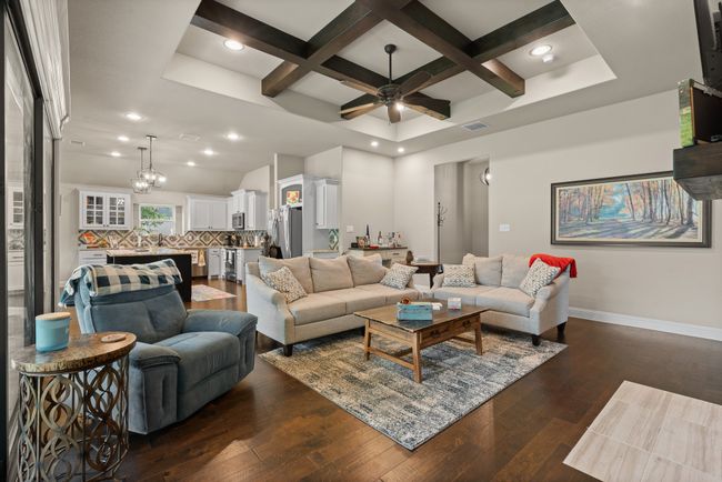 Living room featuring coffered ceiling, ceiling fan, dark wood finished floors, beamed ceiling, and recessed lighting | Image 5