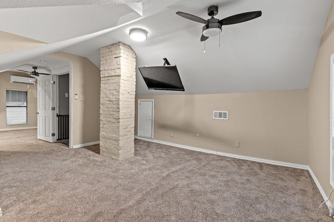 Bonus room featuring ceiling fan, a wall mounted AC, carpet flooring, and lofted ceiling | Image 31
