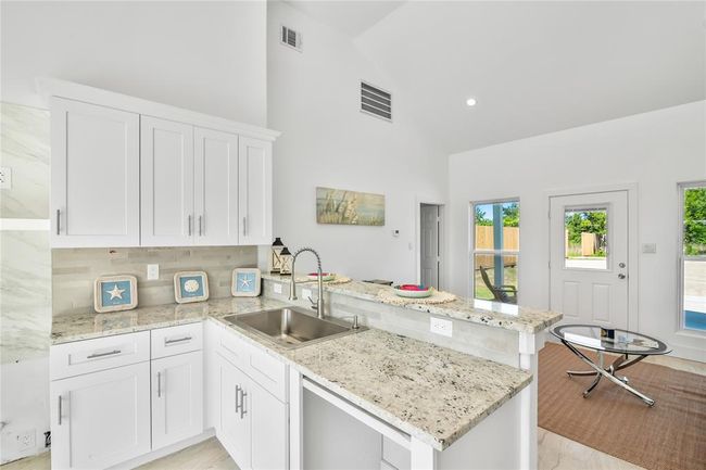 Modern kitchen with sleek white cabinetry, elegant countertops, and a bright, open layout perfect for entertaining. | Image 10