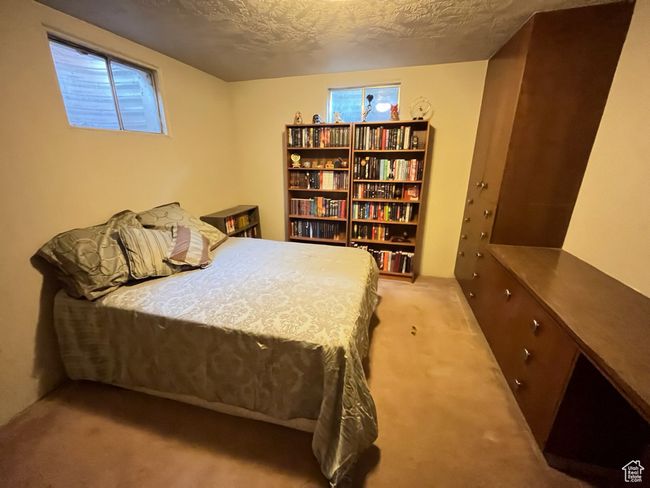 Bedroom with a textured ceiling, multiple windows, and light colored carpet | Image 30